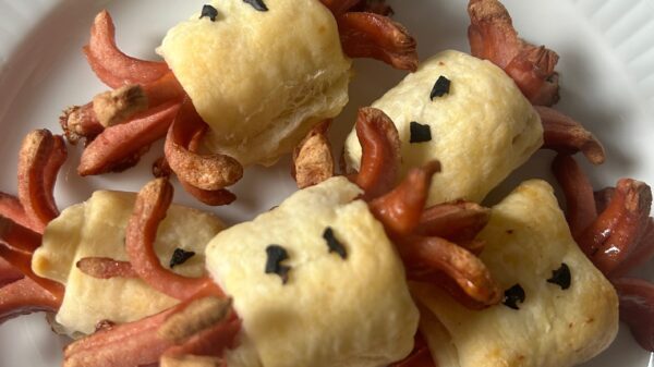 Snack di würstel per Halloween avvolti in pasta sfoglia, per feste e aperitivi. I würstel sono tagliati e incisi per creare divertenti tentacoli che si arricciano durante la cottura, mentre la pasta sfoglia dorata li avvolge al centro. Decorati con pezzetti di olive nere, questi finger food assumono un aspetto giocoso, ideali per buffet o eventi informali. Scopri come preparare questo stuzzichino sfizioso e originale in pochi semplici passi